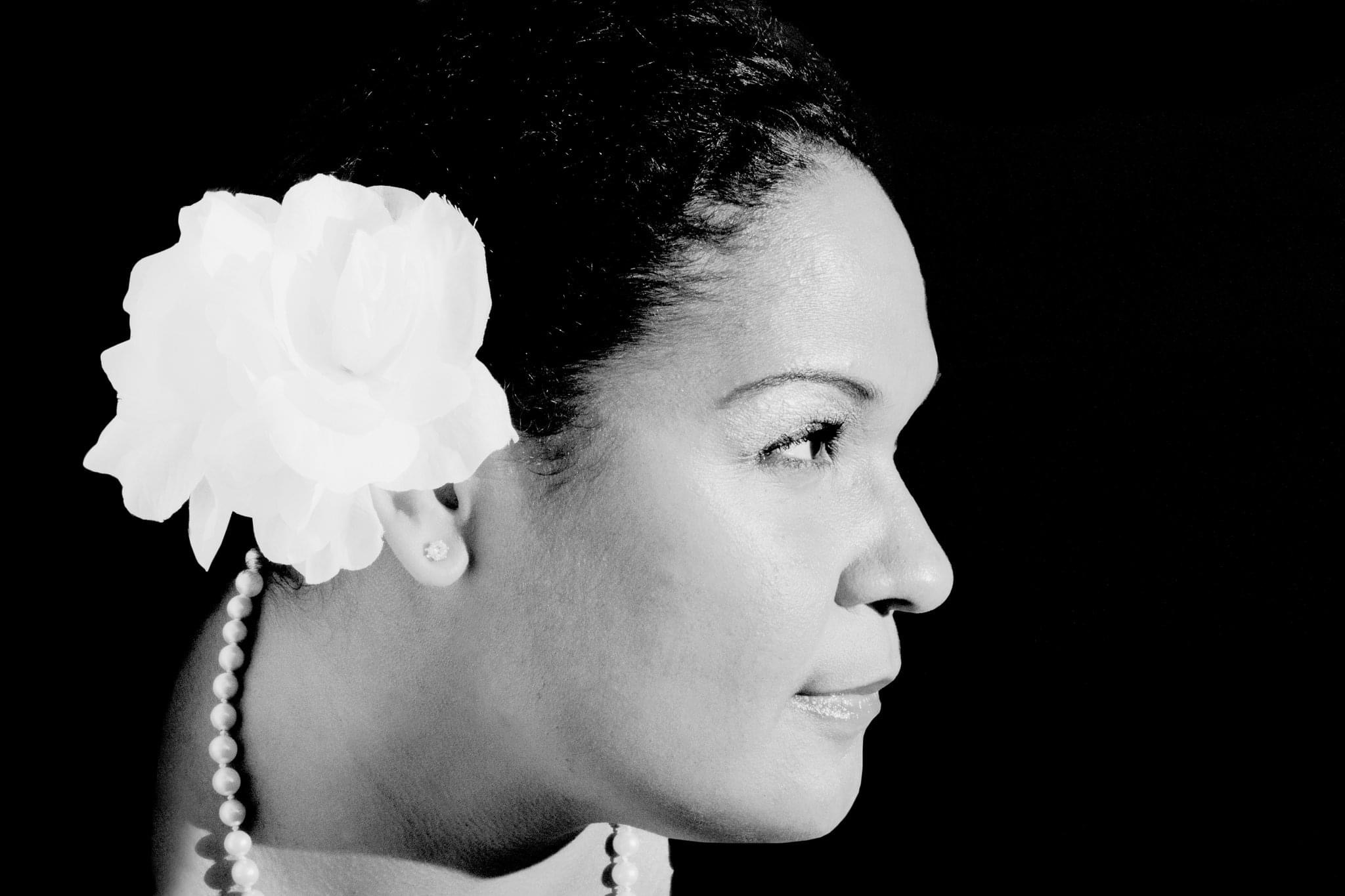 Black-and-white profile of Maya as Billie Holiday with a flower