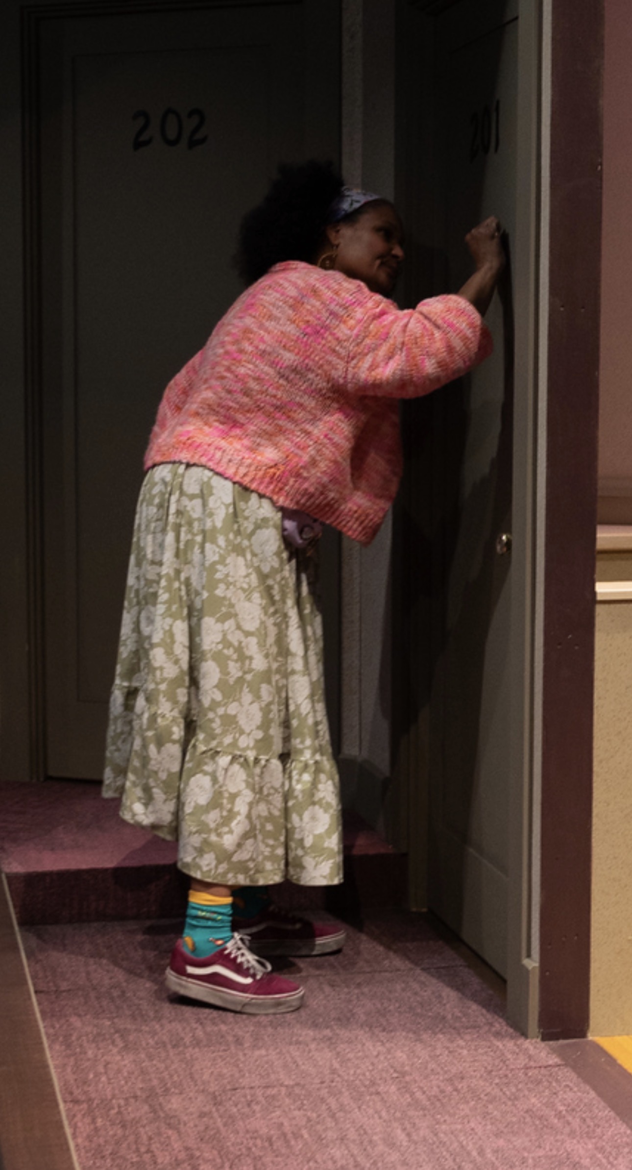 Maya Francine Thomas knocking on an apartment door